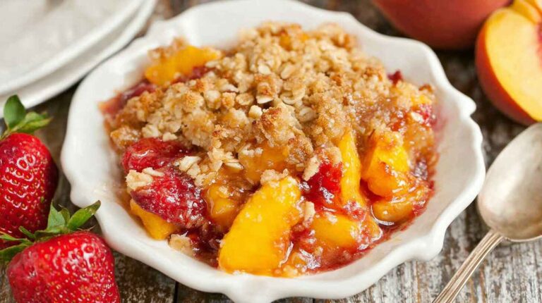Strawberry Peach Crisp: The Perfect Summer Dessert with a Golden Oat Topping 3 Homemade strawberry peach crisp with golden oat topping served in a white bowl